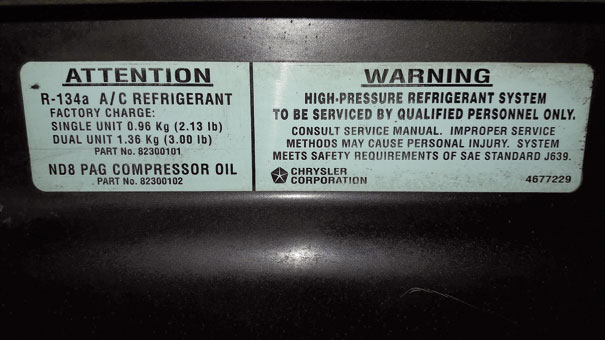 Etiqueta adesiva - Chrysler Caravan 1998 - indicando duas possibilidades de quantidade de fluido refrigerante conforme modelo da caixa evaporadora e também o tipo de óleo lubrificante
